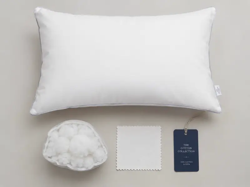 Flat-lay of the pillow, microfiber fill, cotton swatch and hang tag